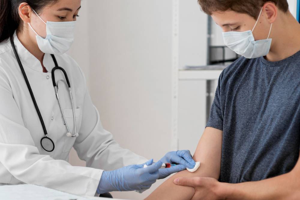 Medical professional in white coat administering a vaccine to person